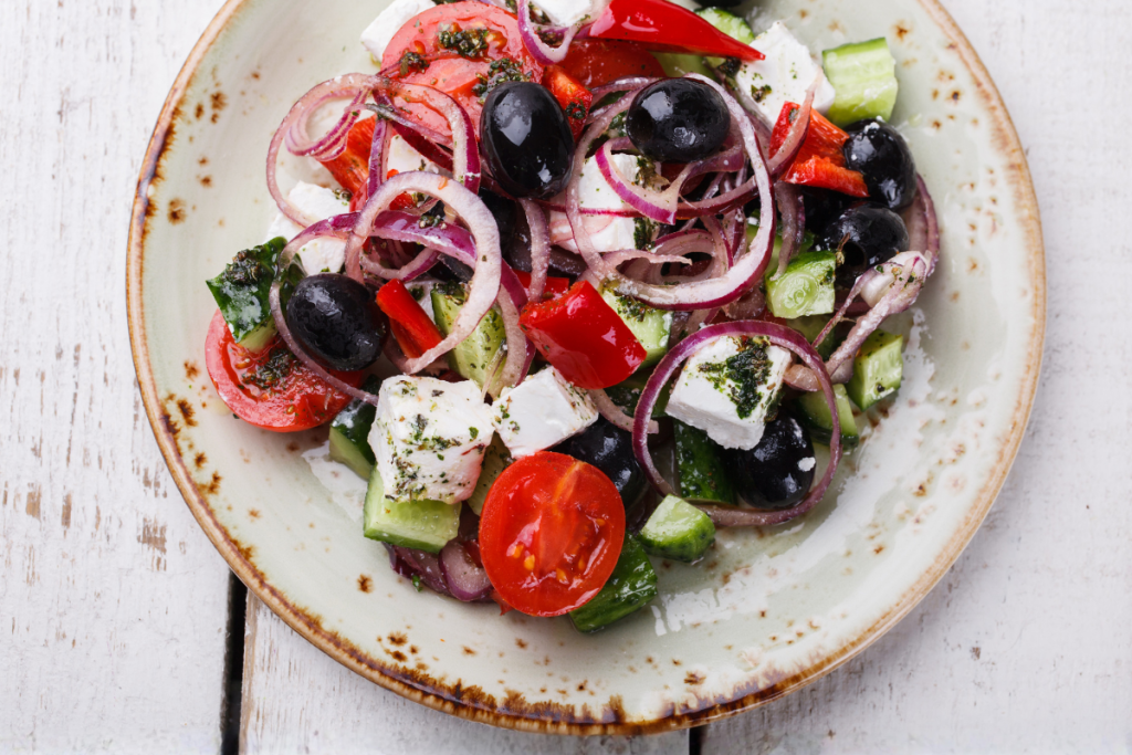 Salade grecque avec tomates, concombre, feta, olives noires, poivron rouge et oignon rouge.